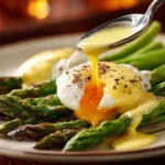 hollandaise sauce drizzled over eggs and asparagus